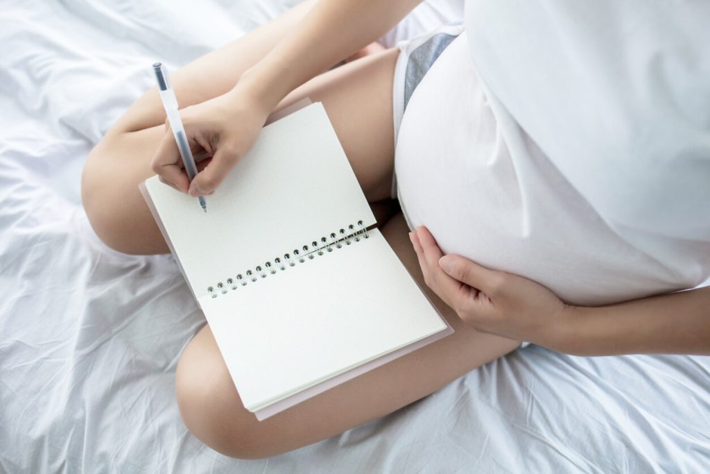 Pregnant woman journaling for emotional health