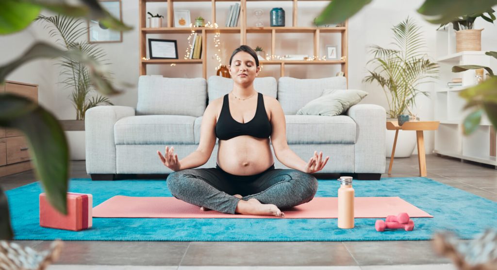 Pregnant woman practicing yoga for a calm pregnancy