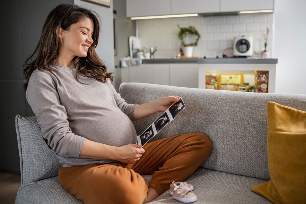 Pregnant woman smiling as she feels the baby for the first time
